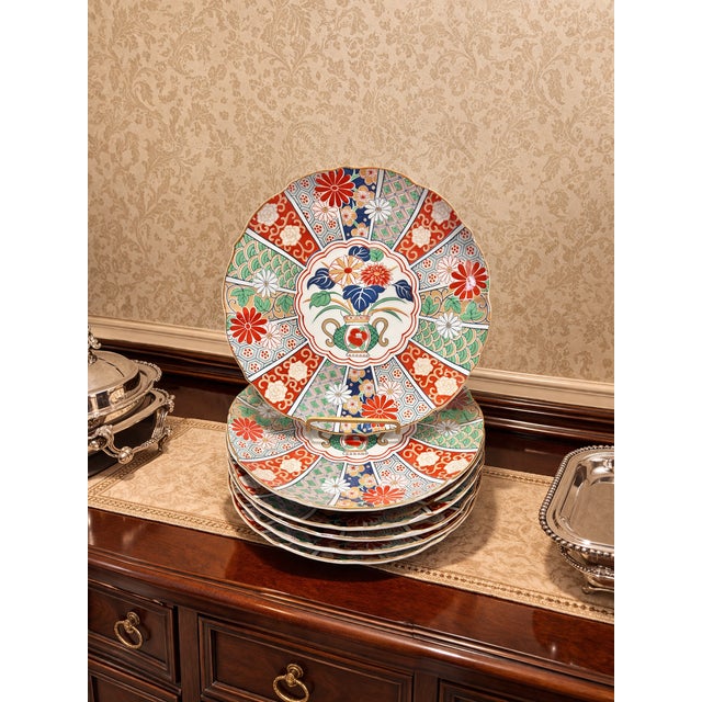 A vibrant set of vintage Arita porcelain Imari dinner plates featuring the classic Japanese floral vase panel motif in...