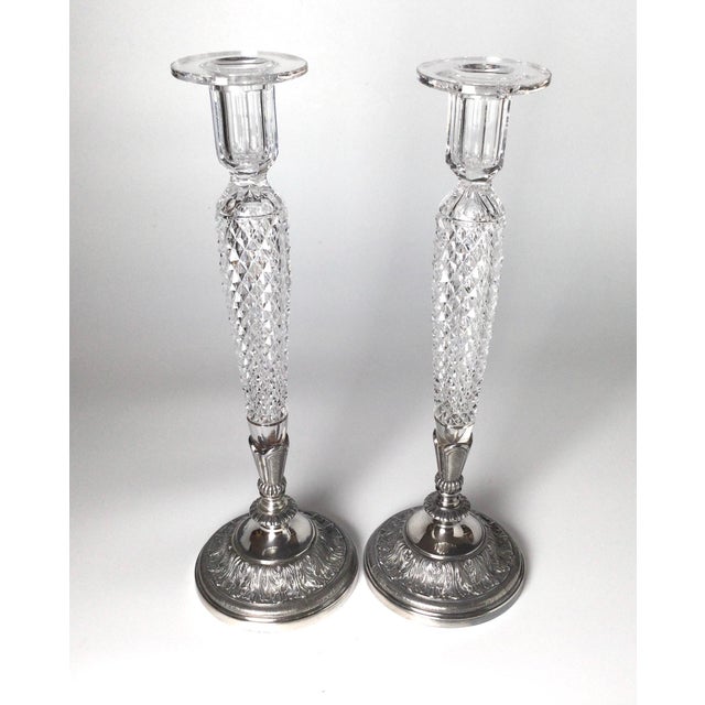 A pair of elegant tall candlesticks with a diamond cut bodies with silver-plate bases with acanthus leaf decoration,...