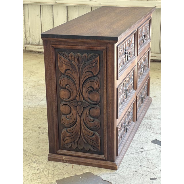 Beautifully ornate, hand carved Mexican dresser circa 1960's featuring six drawers with iron pulls, all move with ease. In...