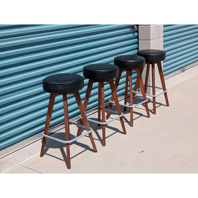 Add timeless sophistication to your space with this pair of vintage Mid-Century Modern bar stools from the 1960s. Crafted...