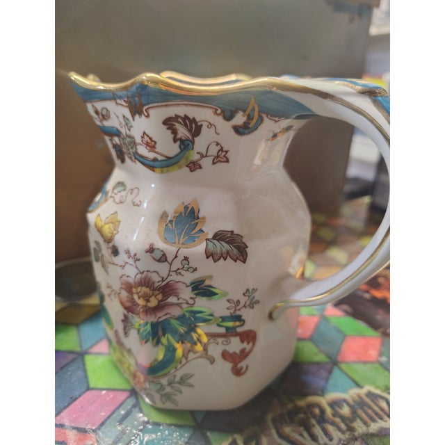 Beautiful example of a vintage iron stone cream colored ceramic custard jug with hand painted vibrant turquoise, rose,...