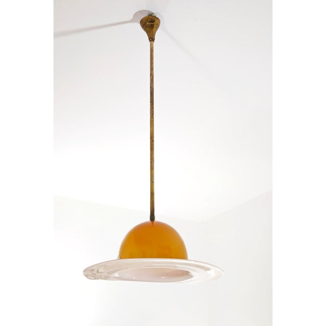 A splendid venini pendant lamp, made in italy around the 1970s, crafted from fine amber and white murano glass in the...