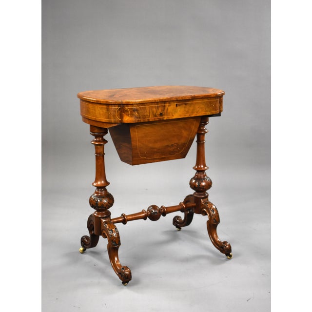A good quality Victorian burr walnut work table, the rising lid opening to a fully fitted interior, above ornately turned...