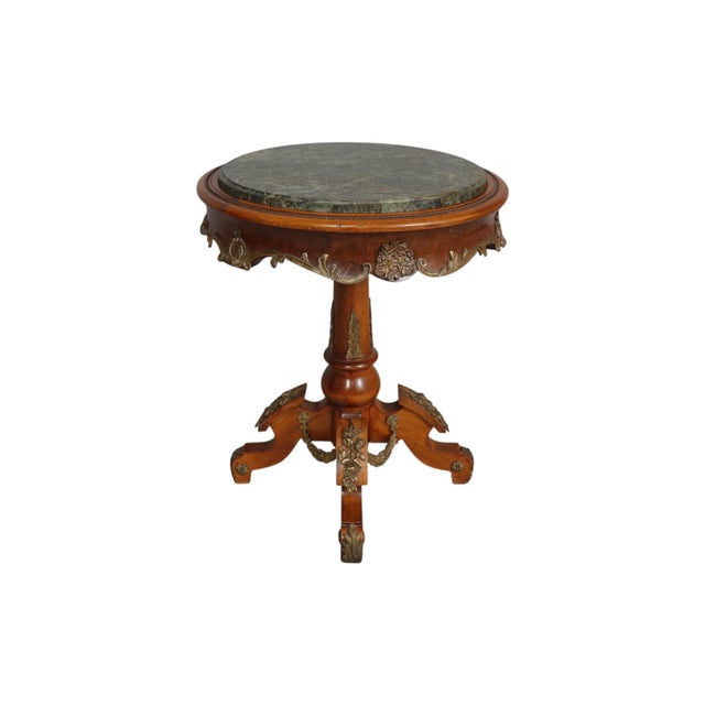 A French Empire period side table in burled walnut, circa 1890. The beveled tabletop is inset with green marble, framed...