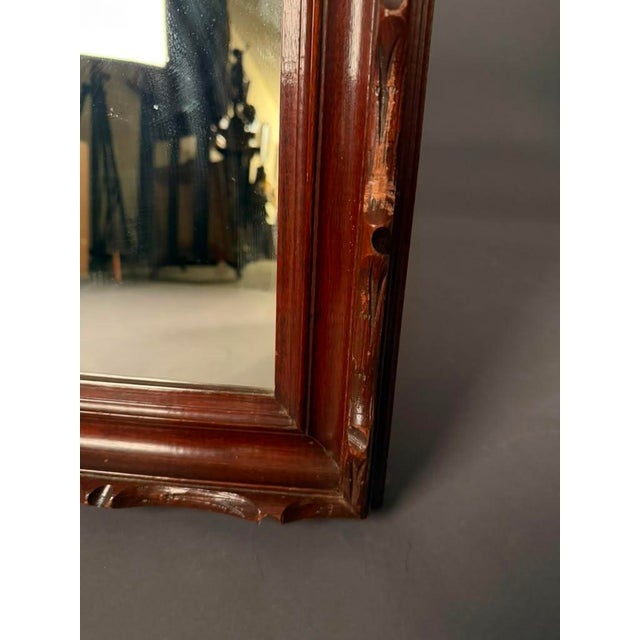 Add warmth and character to any space with this mid-20th century wall mirror, circa 1950. Finished in a rich mahogany-...