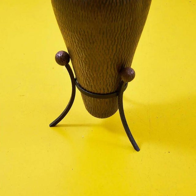 This charming hammered copper pitcher, with its elegant design and metal stand, is a truly special piece of design....