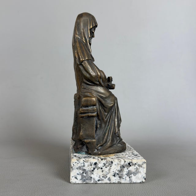 A refined devotional figure, characterized by solemn composure and mounted on a solid stone base. · subject and style:...