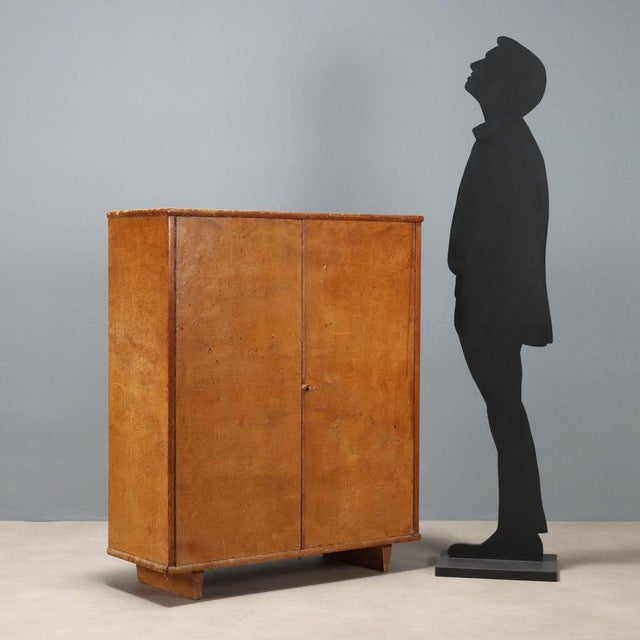 Vintage cabinet with walnut burl veneer featuring hinged doors and internal shelves. This piece is attributed to the...