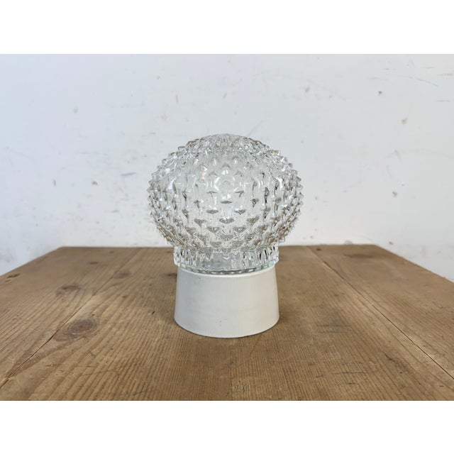 Vintage industrial ceiling or wall light made in former Czechoslivakia during the 1970s. It features a white porcelain...