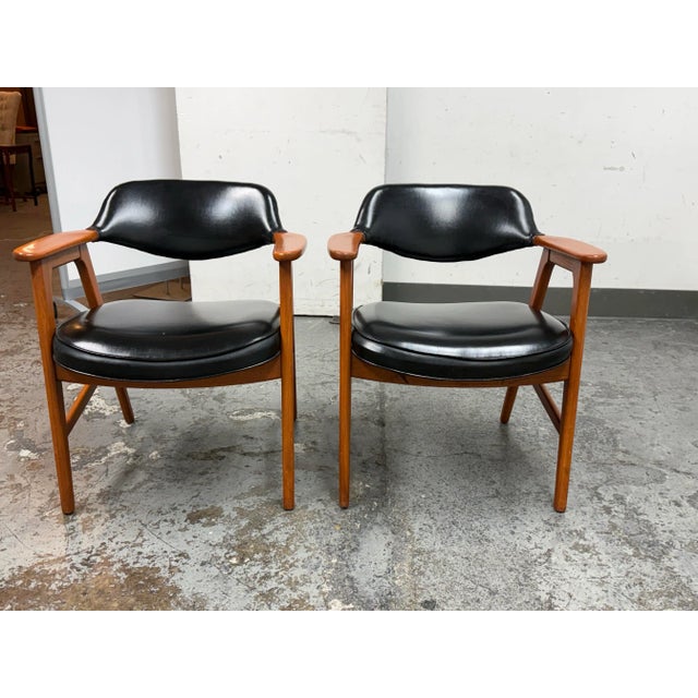 Design Plus Gallery presents a Pair of Walnut Frame and Black Vinyl Arm Chairs from the Mid 20th Century. The have great...