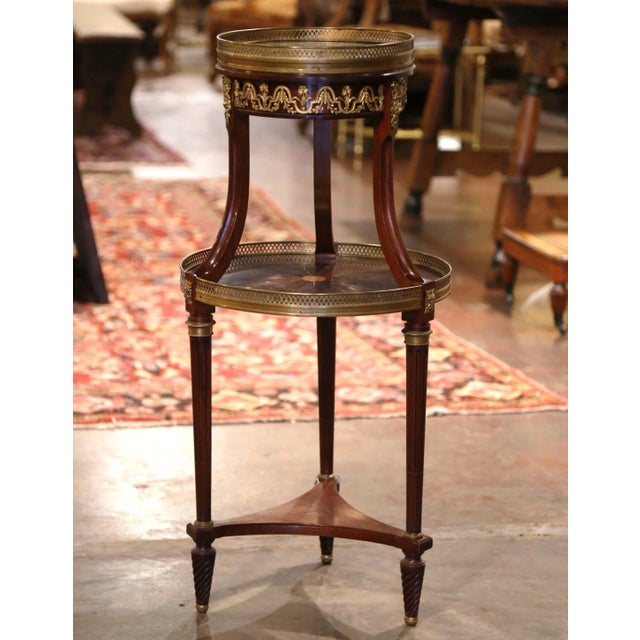 This antique French Louis XVI style bouillotte table combines finely detailed gilt bronze ornamentation with the rich...