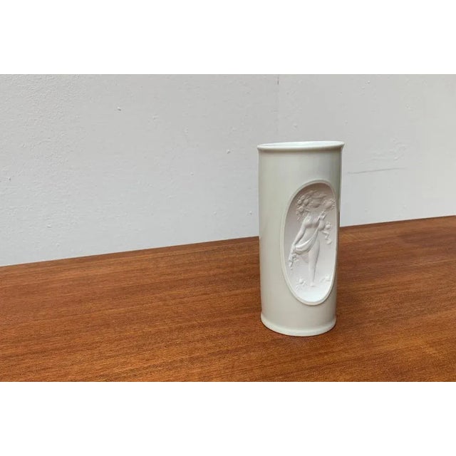Elegant, white porcelain vase based on a design by Bjørn Wiinblad from the 60s. The decor is inset shows a fine relief...