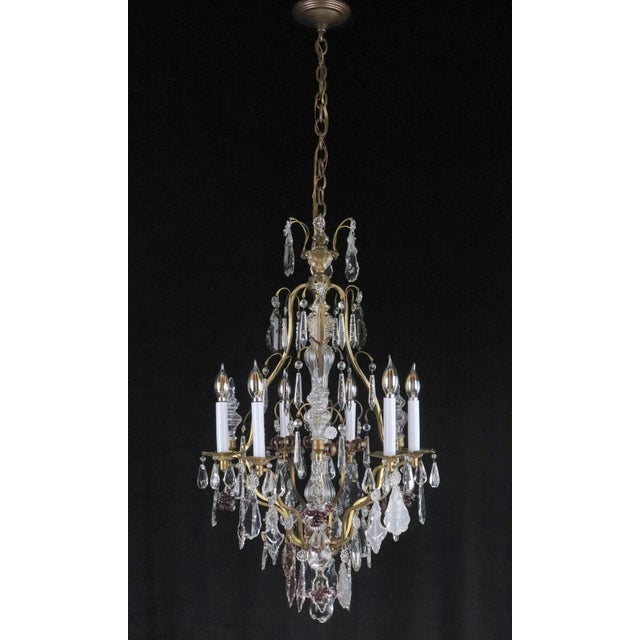 20th century Rococo Revival chandelier. The glass encased central pole and pressed glass rosettes reference Marie Therese...