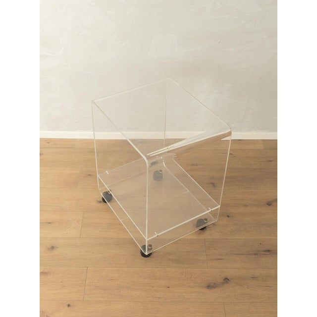 Wonderful side table from the 1960s. High-quality frame made of transparent acrylic with plastic casters. Quality...