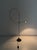 Halogen floor lamp. Black painted metal frame. with a sinuous line, the central stem, made of flexible electrical cable,...
