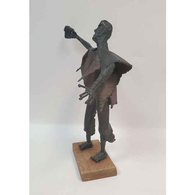 Vintage Brutalist Metal Sculpture of A Man Raising a Glass, marked "WIM", on wood base. Vintage Brutalist-style welded...