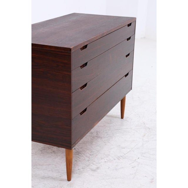 A beautiful vintage rosewood chest of drawers from the 1960s with a clean, compact form and striking, dark grain. The...