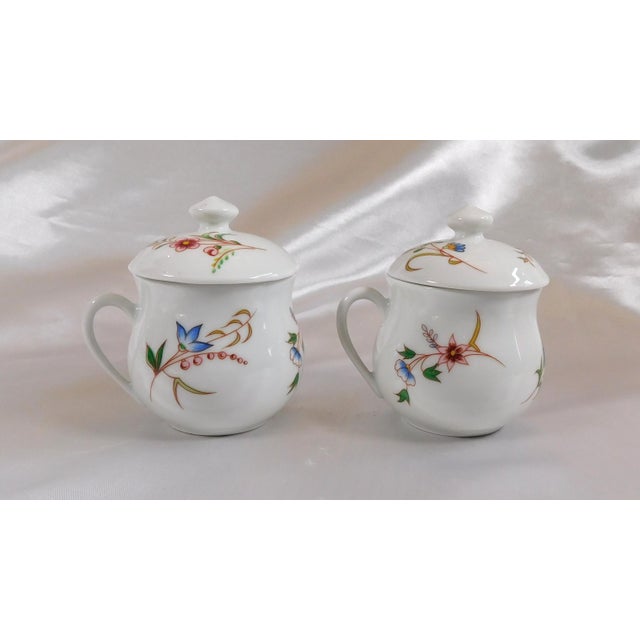 This is a set of two Cordon Bleu BIA France covered chocolate cups. The cups are white with a blue floral design and pink...