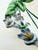 A charming vintage Italian majolica-style ceramic serving dish featuring delicate blue-violet flowers, richly shaded green...