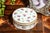 A beautifully refined example of English porcelain artistry, this stunning circular white porcelain box is adorned with a...