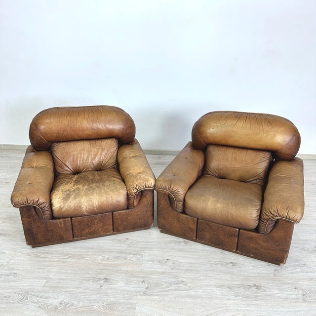 Dimensions: H 32” x W 39.5” x D 34” x SH 18” Pair of Vintage Italian brown leather club chairs from the 1960s. Manifattura...
