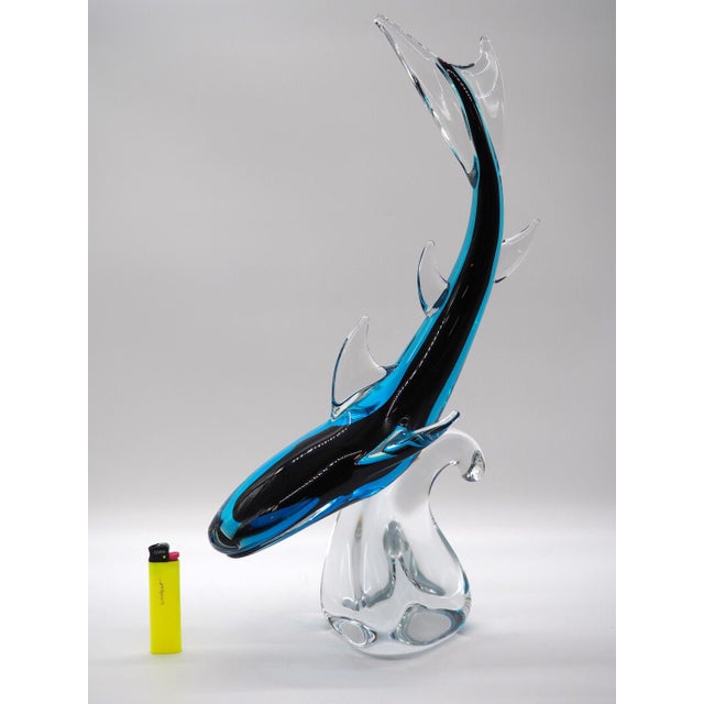 A truly wonderful glass sculpture of a shark surfing on the wave. The light reflects so beautifully, and the blue color...