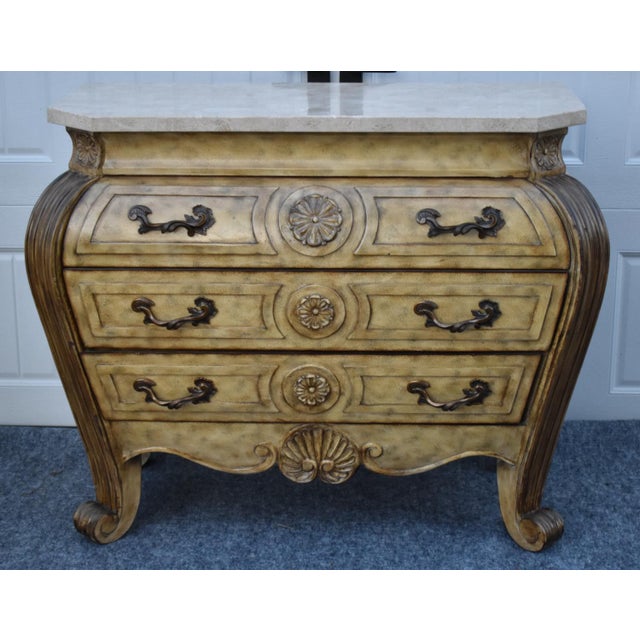 Vintage (1990's) Bombe Commode has a Tuscan Style. The Commode has a marble Top with Three Drawers and Carved Wood in a...