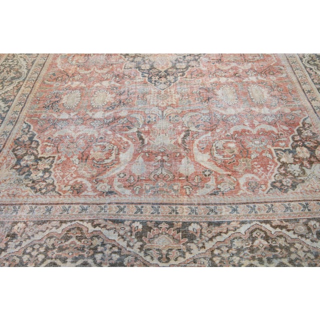 This beautiful 1920s antique mahal wool rug features a rust-colored main field and secondary colors of blue, beige, and...