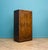 A 1930s Art Deco compact gentleman’s wardrobe with bookmatched walnut veneer to the twin doors, forming a mirrored grain...