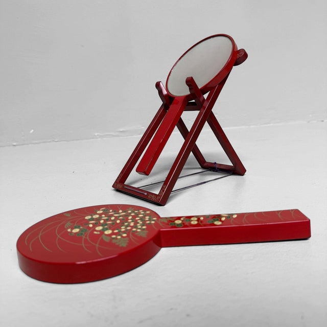 A charming set of two hand mirrors with a folding stand, preserved in its original box. Dimensions: nested together, 26 cm...