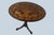 Wonderfully crafted circular flip top table with a floral motif surrounding a Roman antiquity style vase and a bird in...