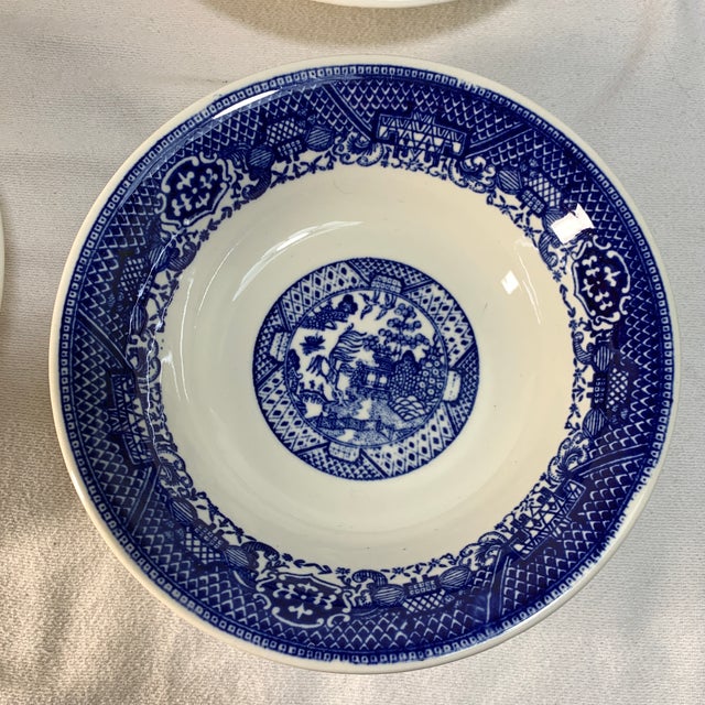 The image shows a set of four vintage mid-20th-century Blue Willow cereal or soup bowls featuring the classic Chinoiserie...