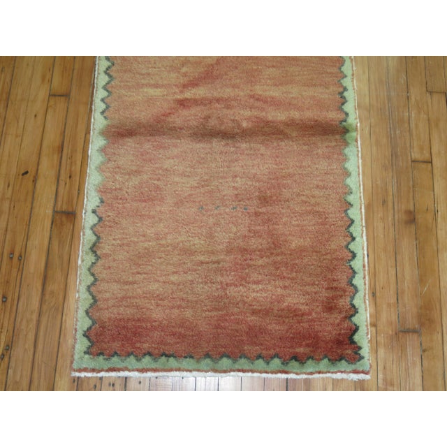 One of a kind mid-20th century Turkish modernist style rug in brick red. Border is in soft green Measures: 2'6" x 4'2".