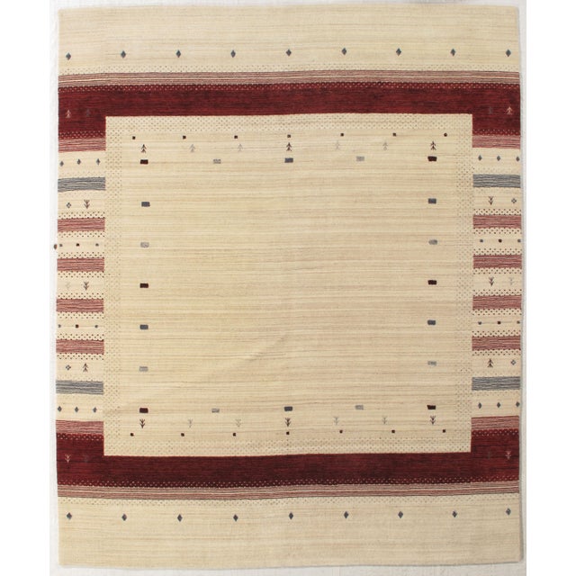 Vintage hand-knotted Indo Gabbeh rug with a plain field framed by geometric and linear borders, with small tribal motifs....