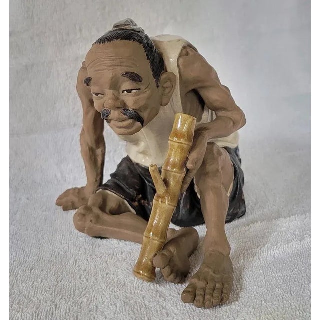 19/20th C, finely rendered Chinese Shiwan (Shekwan) pottery statue of a seated man holding a bamboo pipe traditionally...
