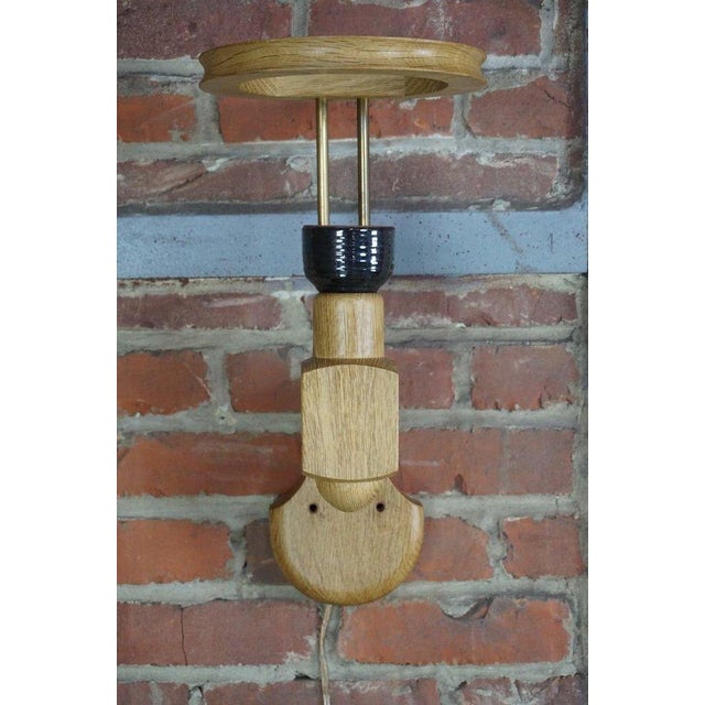 This solid oak wall light is in perfect condition and working order, featuring a ceramic socket by Boleslaw Danikowski and...