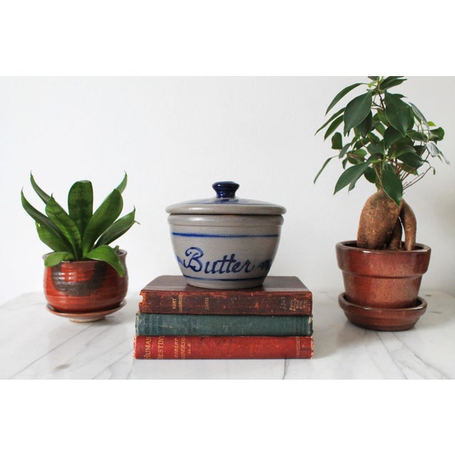 Blue and gray lidded butter crock by Rowe Pottery Works. Dated 2000. One unseen chip on inside rim. Pictured.