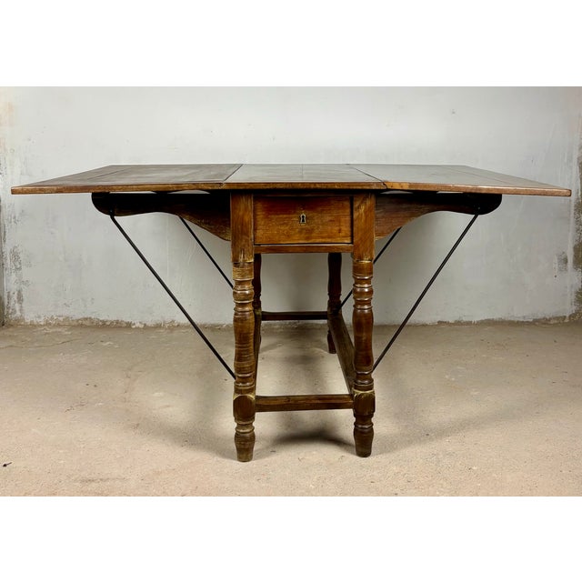 Charming Spanish drop-leaf dining table crafted in wood, dating from the early 20th century. Designed with two hinged...