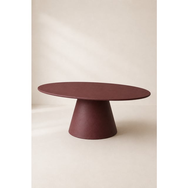 Burgundy red microcement oval table, custom-made by Andrea Toffanin, Hood – Back & Forth Design. The essential shape of...