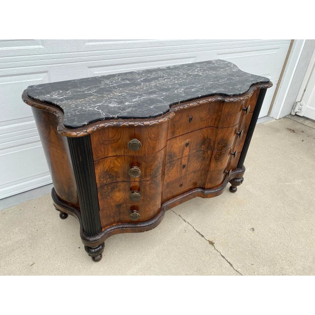 A truly exceptional antique walnut serpentine commode, showcasing masterful craftsmanship and dramatic materials...