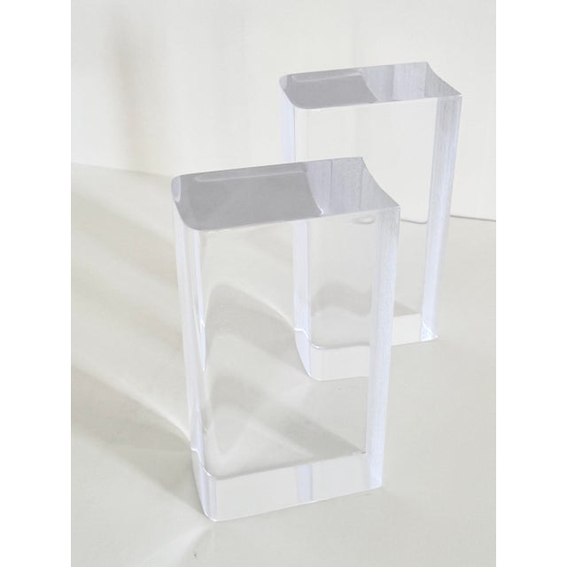 A pair of Lucite bookends in the form of stylized books, dating from the 1940s or 1950s. Made of clear Lucite with softly...