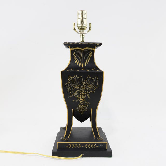 This vintage black tole table lamp features exquisite hand-painted details with a classical European flair. One side...