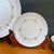 Delicate vintage bread-and-butter plates from the Wyndham “Buttercup” pattern, featuring soft yellow and blue florals...