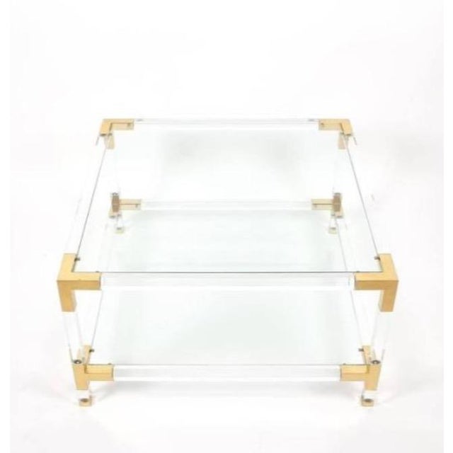 A Hollywood Regency coffee or cocktail table with 2 glass shelves. This gorgeous table is attributed to Charles Hollis...