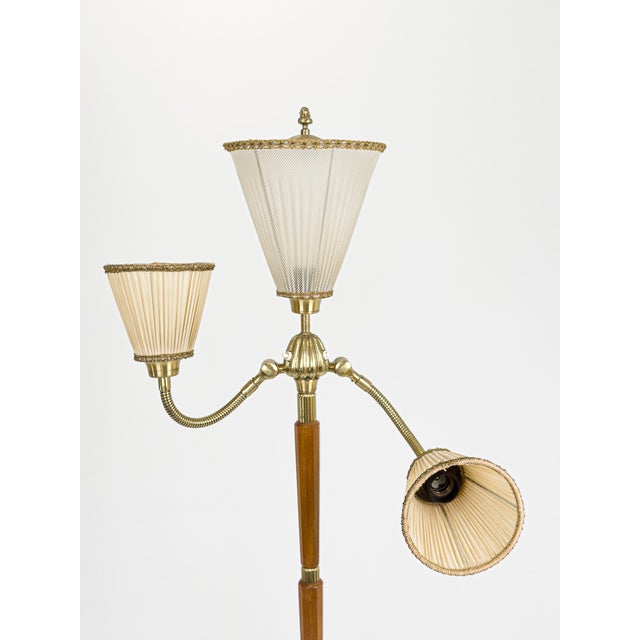A striking Swedish Modern floor lamp executed in richly grained mahogany with refined brass detailing, Sweden, circa...