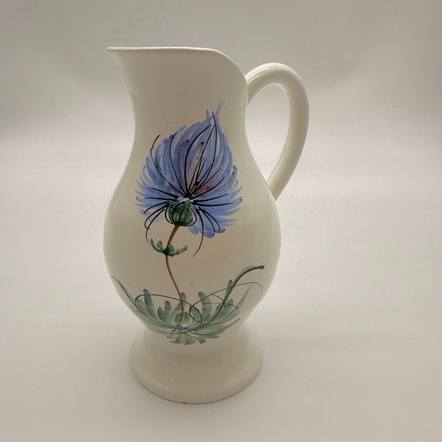 A vintage Céramique Fady Vallauris pitcher featuring hand-painted blue thistle motifs is a classic mid-century piece of...