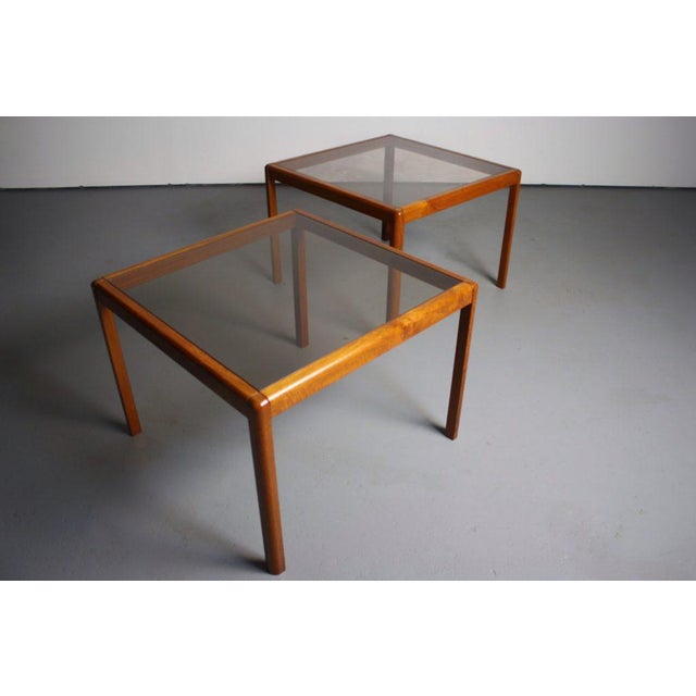 Minimalist design. A set of two teak end tables w/ smoked glass table tops.