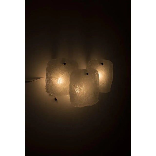 A wonderful wall lamp from kalmar franken kg, 1960s. The lamp is made from beautiful ice glass on a metal holder. In good...