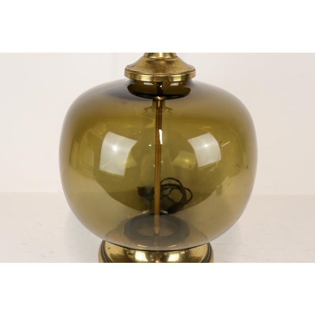 This fabulous MCM lamp features a generous olive green smoked glass globe paired brass accents, making it a beautiful...