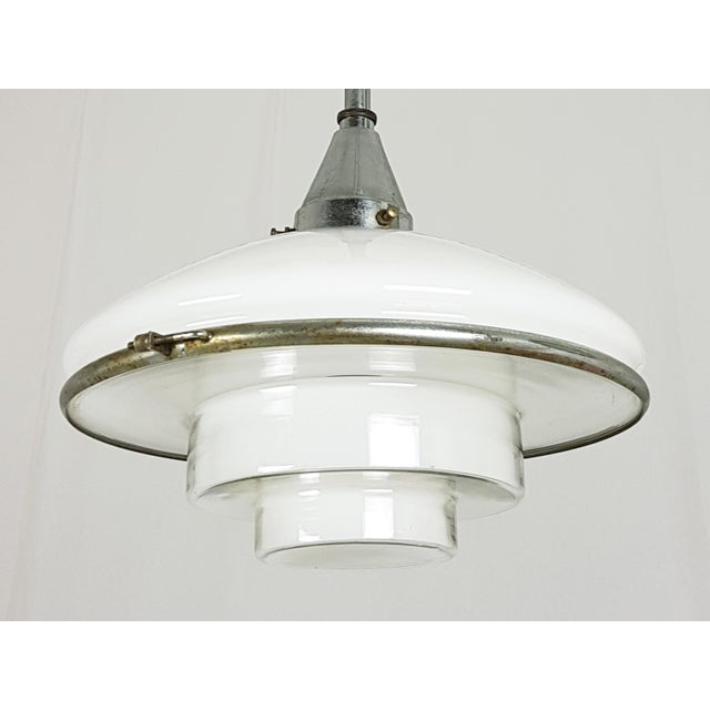 This pendant lamp was designed by Otto Müller in 1931 and manufactured by Megaphos/Sistrah Licht GmbH in Germany. It is...